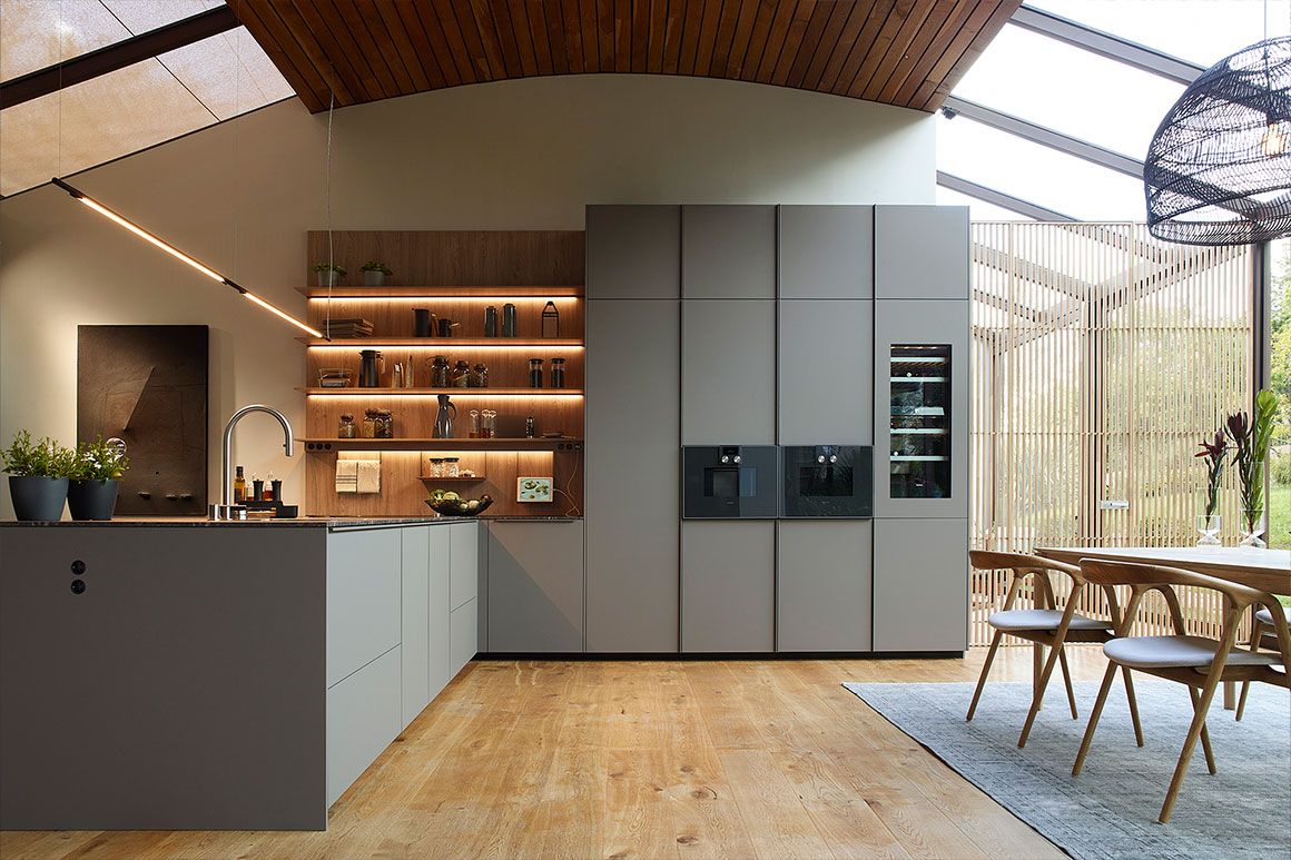 cocina gris con peninsula y estanteria con iluminacion santos